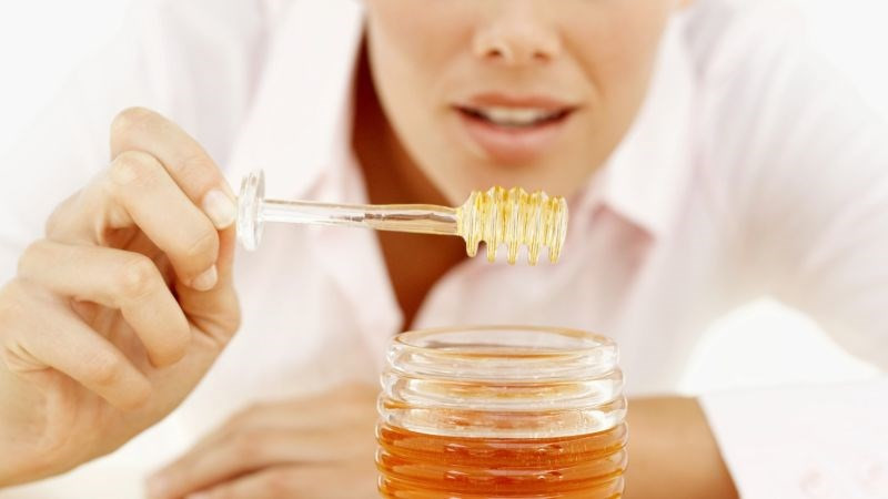 Người phụ nữ đang thoa mật ong lên mặt để dưỡng ẩm sâu cho da