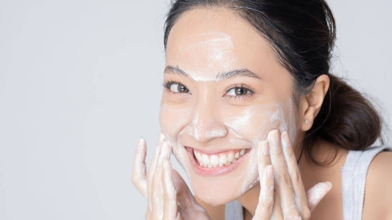 Góc chụp cận cảnh bàn tay đang rửa mặt, thể hiện tầm quan trọng của việc làm sạch da hai lần mỗi ngày để ngăn ngừa mụn.