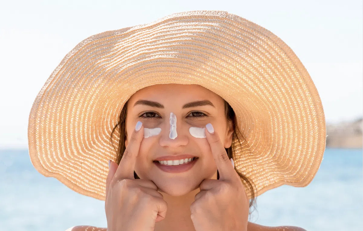 Kem chống nắng được thoa lên làn da, tượng trưng cho lớp bảo vệ vững chắc chống lại tia UV gây hại từ ánh nắng mặt trời, một yếu tố quan trọng trong chiến lược dưỡng da mặt chống lão hóa hiệu quả.