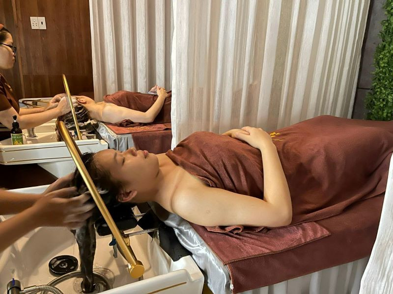Kỹ thuật viên đang thực hiện liệu pháp gội đầu dưỡng sinh tại Mộc Spa, sử dụng các sản phẩm thảo dược tự nhiên