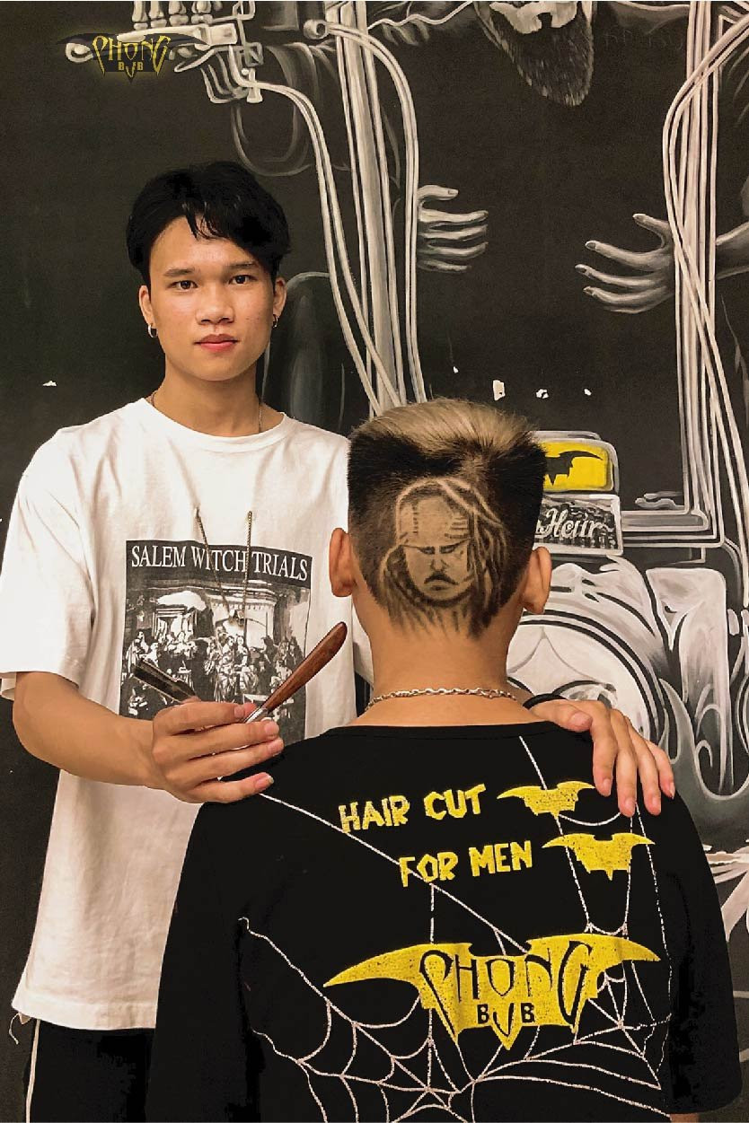 Một barber đang tạo kiểu tóc Pompadour cho khách hàng tại cửa hàng.