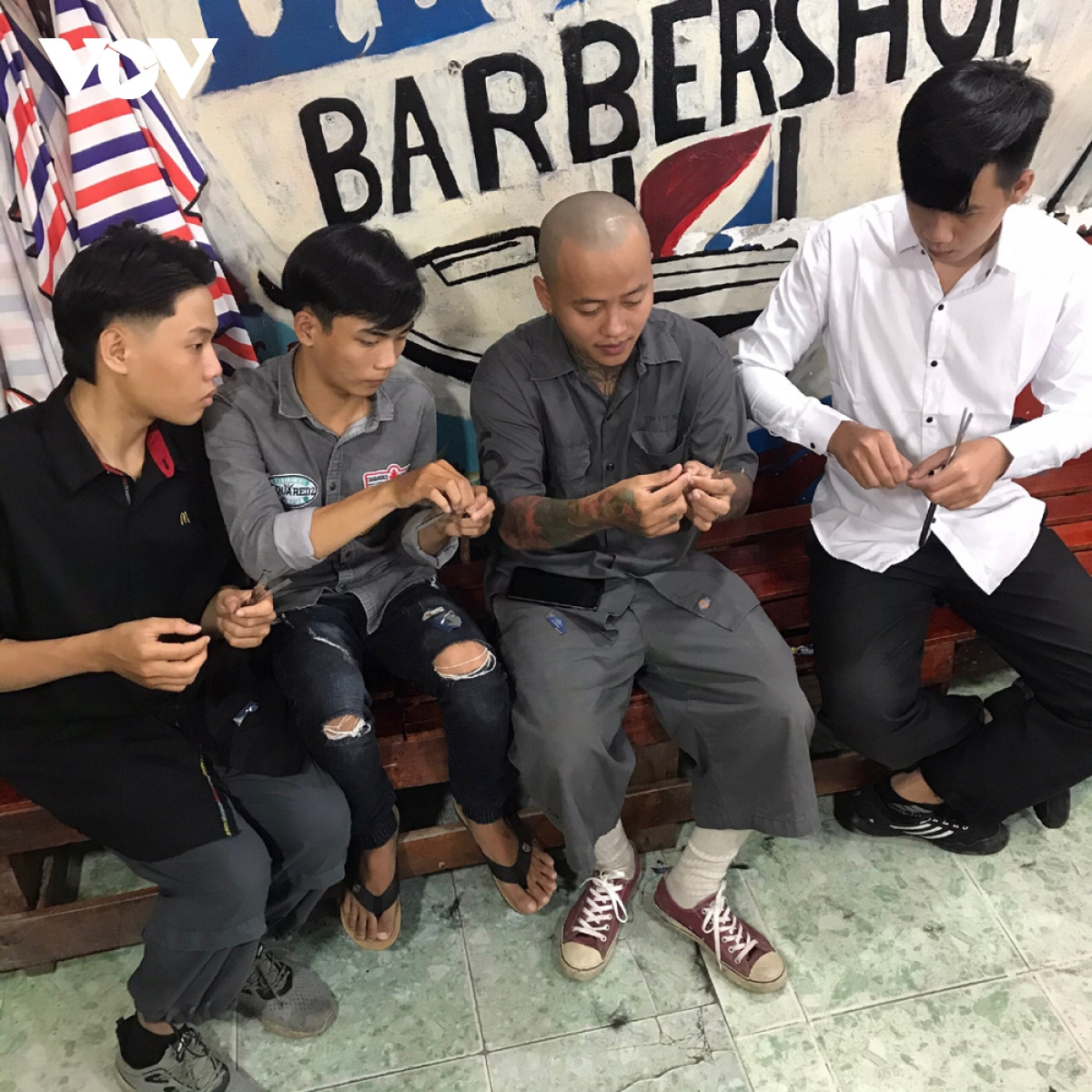 Thợ cắt tóc đang tập trung làm việc tại một tiệm Barber Shop, thể hiện sự chuyên nghiệp và tỉ mỉ trong từng đường kéo, đảm bảo khách hàng có một mái tóc ưng ý.