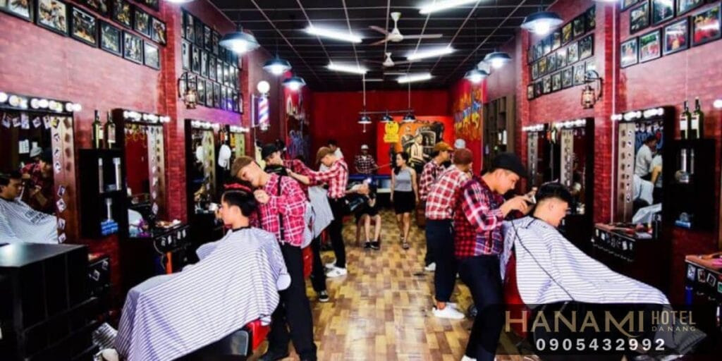 Thợ cắt tóc đang thực hiện dịch vụ tỉa tóc cho khách hàng nam tại một barber shop, thể hiện sự chuyên nghiệp và tỉ mỉ trong từng đường kéo, phù hợp với hình ảnh Tóc Nam Đẹp Sáng Tạo.