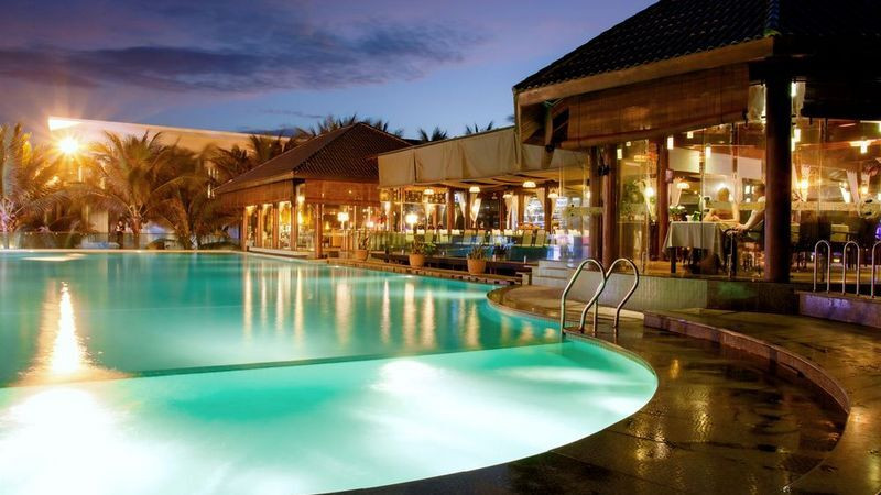 Bàn ăn lãng mạn bên hồ bơi tại Villa Del Sol Beach Mui Ne, sẵn sàng phục vụ các món ăn ngon