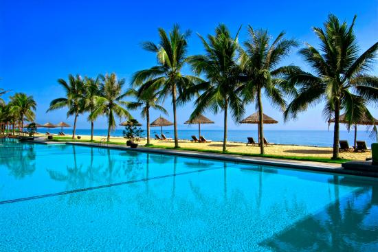 Quang cảnh bể bơi và khu vực ghế nằm thư giãn nhìn ra biển tại Golden Sand Resort and Spa Hội An