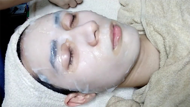 Khách hàng thư giãn khi đang được đắp mặt nạ dưỡng chất chuyên sâu tại spa, một bước quan trọng trong quy trình chăm sóc da cơ bản.