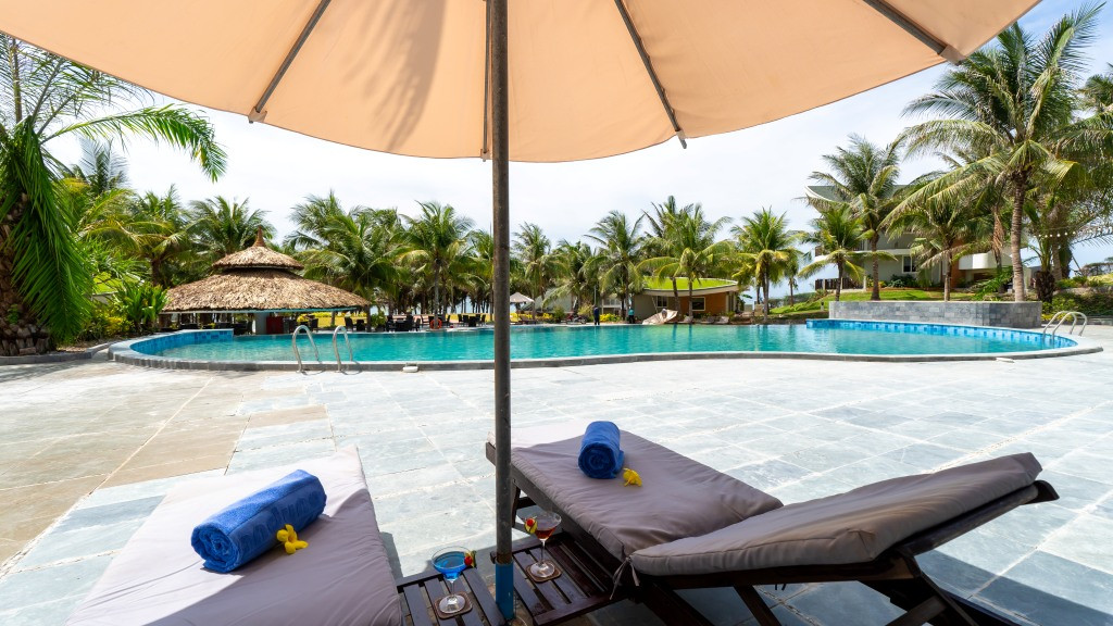 Khu vực bên ngoài của một căn biệt thự tại Sandunes Beach Resort &amp; Spa Mũi Né với cây xanh và lối đi