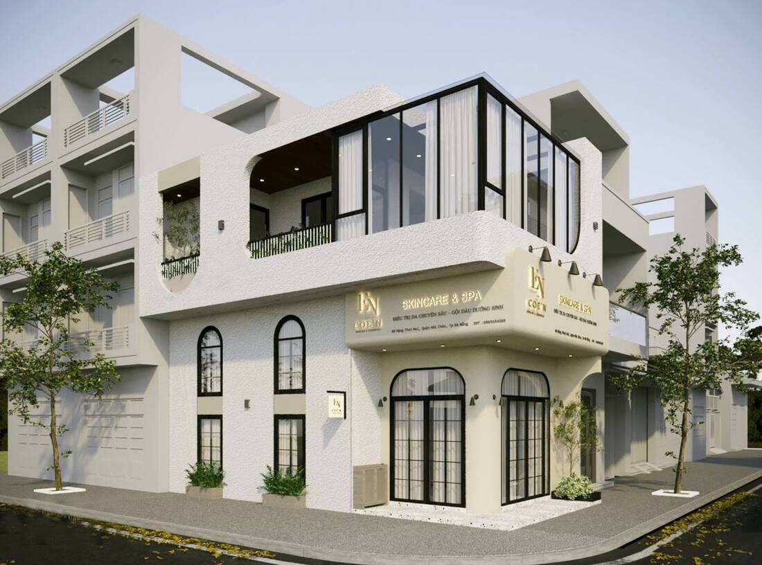 Mặt tiền spa hai tầng với thiết kế cửa dạng vòm cổ điển và cây xanh