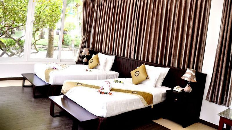 Một căn phòng Grand Premium Deluxe Garden View đặc biệt tại Villa Del Sol Beach Resort &amp; Spa, có ban công riêng nhìn ra vườn và một phần biển