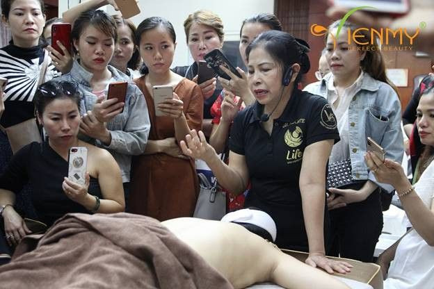 Một nhóm chuyên gia spa hoặc quản lý đang mỉm cười và giao lưu trong không gian chuyên nghiệp