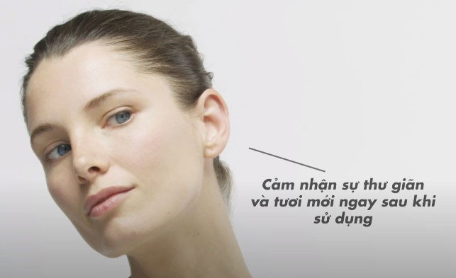 Người phụ nữ đang sử dụng máy galvanic spa của Nuskin để nâng cơ mặt, với các gel đặc biệt