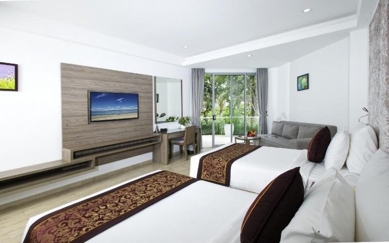 Phòng Deluxe Garden View tại Golden Peak Resort &amp; Spa Nha Trang với ban công nhìn ra khu vườn nhiệt đới xanh tươi
