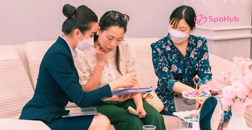 Xác nhận lịch hẹn và thông tin dịch vụ với khách hàng tại quầy lễ tân spa