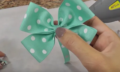 Gắn 1 dải vải chữ nhật lên phía dưới điểm chính giữa chiếc nơ