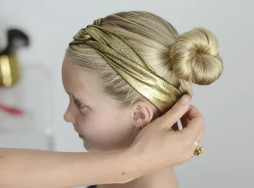 Bé gái với kiểu tóc búi lệch đơn giản cùng băng đô ren, thể hiện sự đáng yêu theo cách búi tóc cute