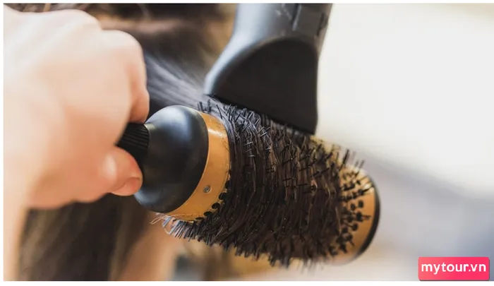 Sử dụng lược tròn đặt bên dưới mỗi lớp tóc và cuốn lại, sau đó dùng máy sấy