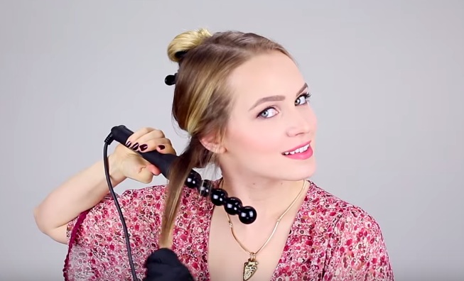 Dùng dụng cụ uốn để tạo lọn tóc sóng mềm mại trước khi tết [Hình minh họa]