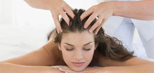 Mô tả cụ thể bàn tay đang massage nhẹ nhàng da đầu của một người phụ nữ