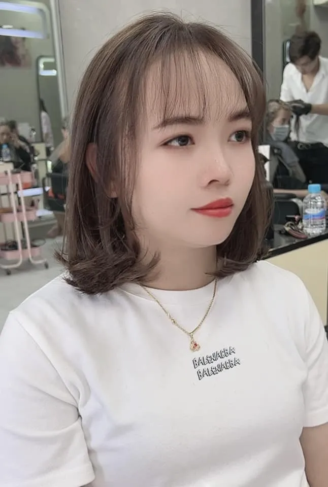 Cô gái với mái tóc đen dài, thẳng mượt, đang chăm sóc tóc sau khi nhuộm