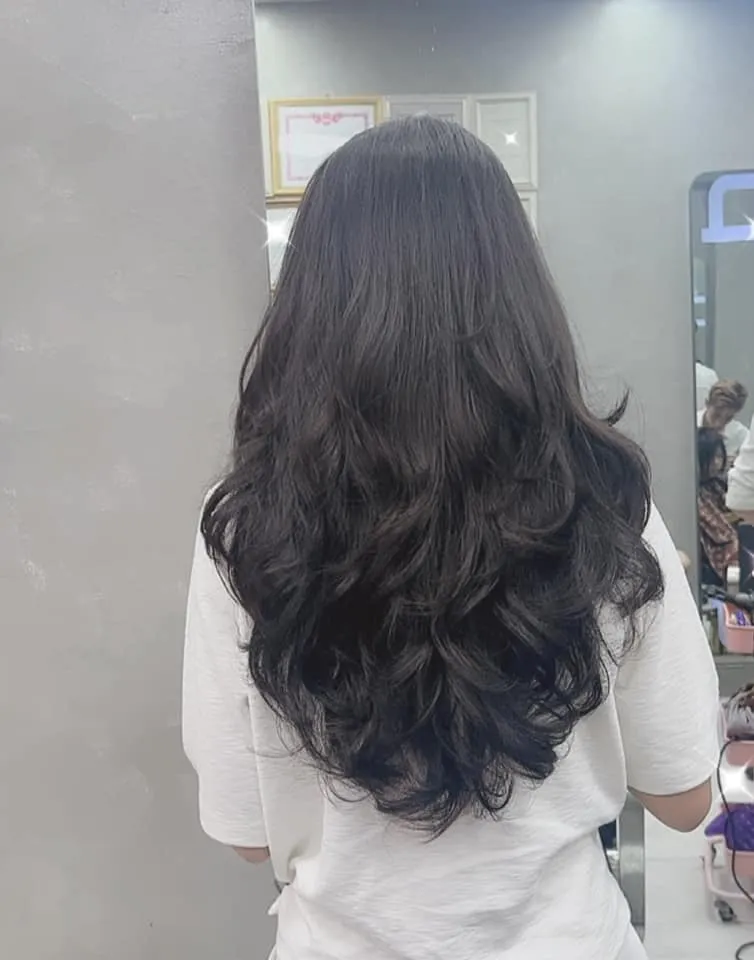 Mô hình tóc đen suôn mượt, được tạo kiểu bồng bềnh, toát lên vẻ đẹp thanh lịch