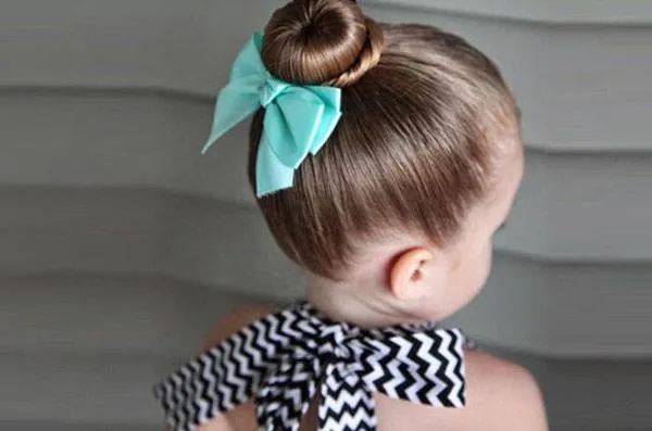 Sành điệu và đáng yêu với kiểu tóc búi đơn giản, dễ làm cho bé gái trong những chuyến đi chơi cùng gia đình.