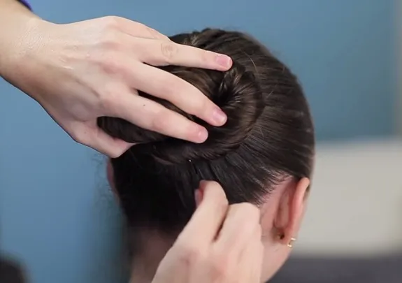 Hình ảnh cận cảnh búi tóc đã được cố định hoàn chỉnh bằng kẹp tăm, thể hiện rõ hình dáng số Tám nằm ngang