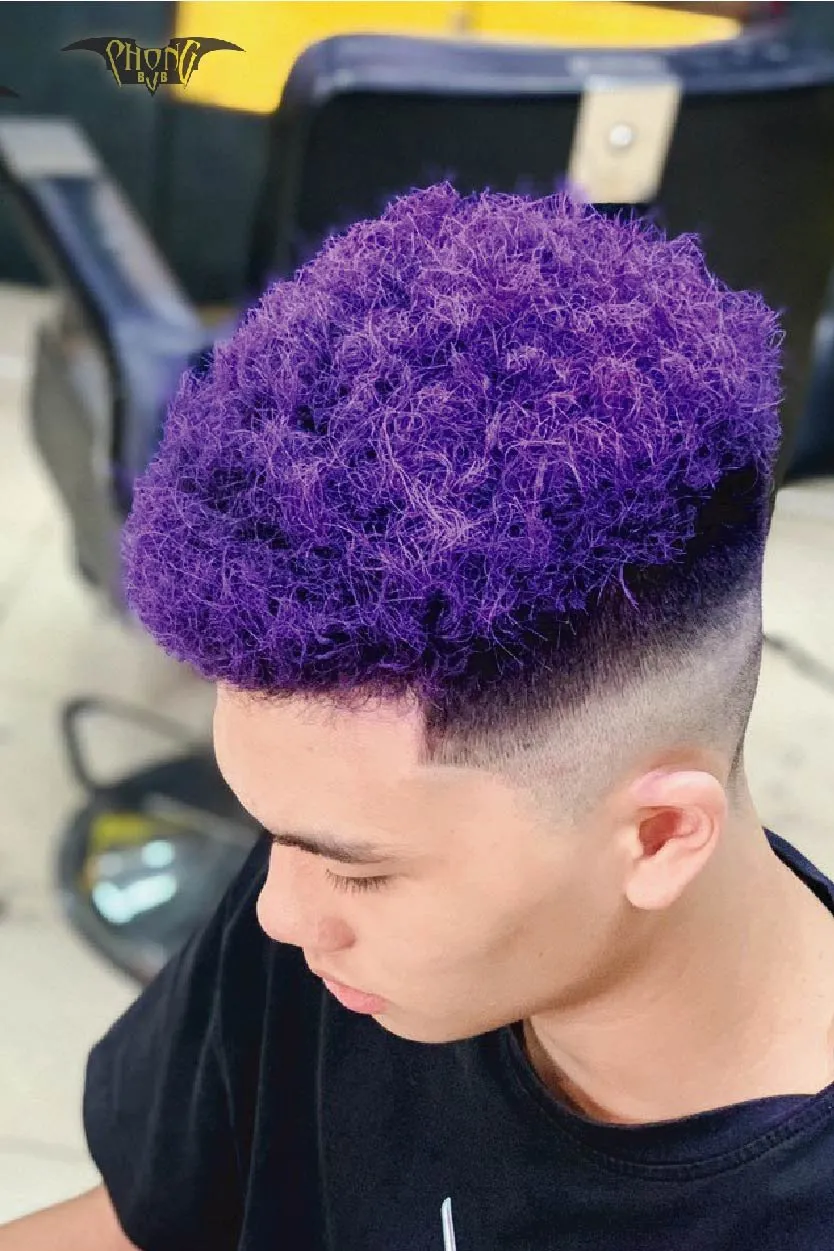 Hình ảnh một người đang thoa dầu xả hoặc kem ủ tóc, minh họa tầm quan trọng của việc dưỡng ẩm để giữ nếp tóc xoăn bền lâu