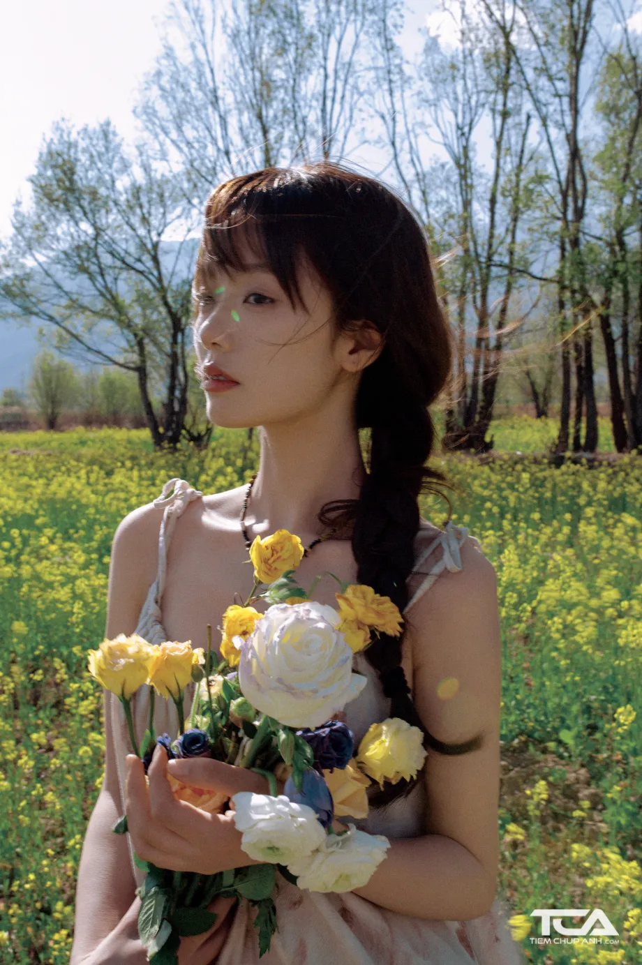 Tạo hình cách làm tóc chụp ảnh kỷ yếu với tóc tết một bên kèm hoa cài lãng mạn