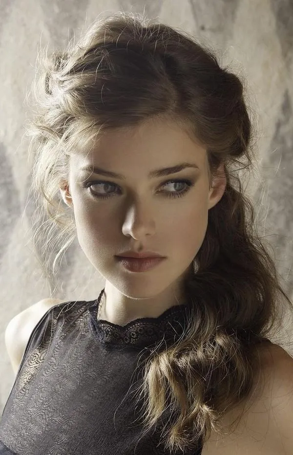 Kiểu tóc đuôi ngựa xoăn nhẹ với lọn tóc rủ hai bên làm mềm góc cạnh khuôn mặt