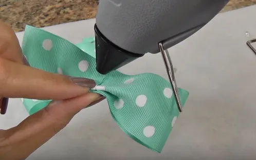 Sau đó tiếp tục gấp hai bên phần chưa gắn keo xuống dưới, phết keo vào đoạn gấp và gắn lại