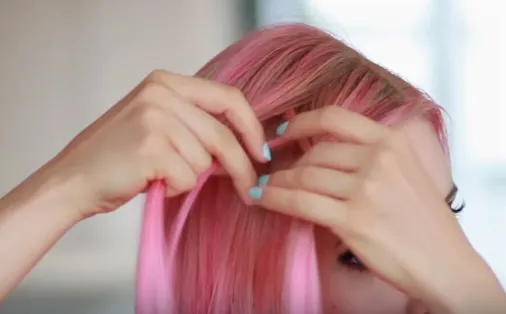 Tách một lọn tóc mỏng ở trên, luồn xuống dưới và gộp vào lọn dưới