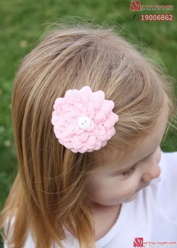 Chiếc hoa kẹp tóc hoàn thiện được làm từ ruy-băng lượn sóng màu hồng, nhìn duyên dáng và tỉ mỉ