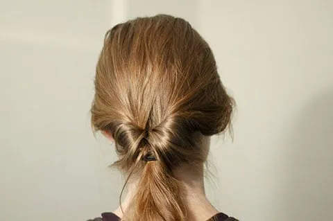 Cách lộn ngược đuôi tóc qua khe hở phía trên dây thun để tạo nền búi tóc cổ điển