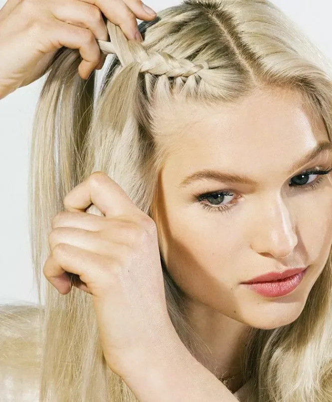 Bắt đầu tết tóc theo thứ tự từ dưới lên trên. Phần tóc bên phải đi dưới phần giữa, sau đó phần tóc bên trái đi dưới phần chéo của 2 phần trên.