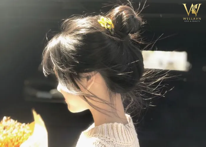 Hình ảnh một nữ sinh với kiểu búi tóc cao gọn gàng, thể hiện sự năng động phù hợp với môi trường học tập