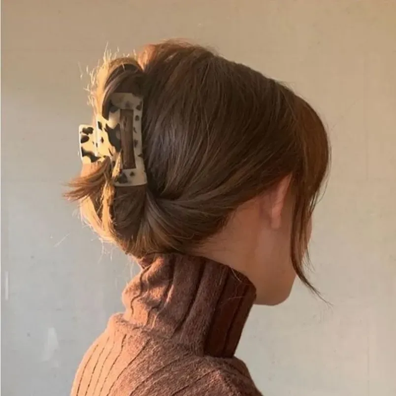 Người mẫu búi tóc ngắn ngang vai kiểu búi cao năng động, làm nổi bật đường nét gương mặt