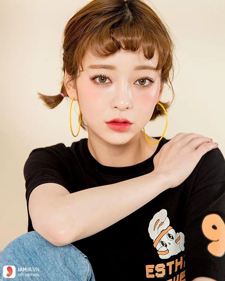 Tóc buộc hai bên với mái ngố dày thưa tạo hiệu ứng thu gọn khuôn mặt đáng kể