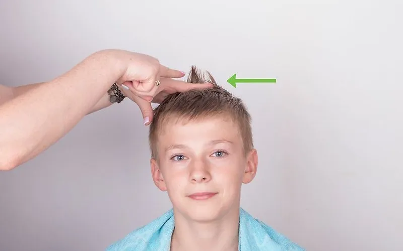 Dùng lược để xác định độ dài và chia tóc khi cắt tóc cho bé