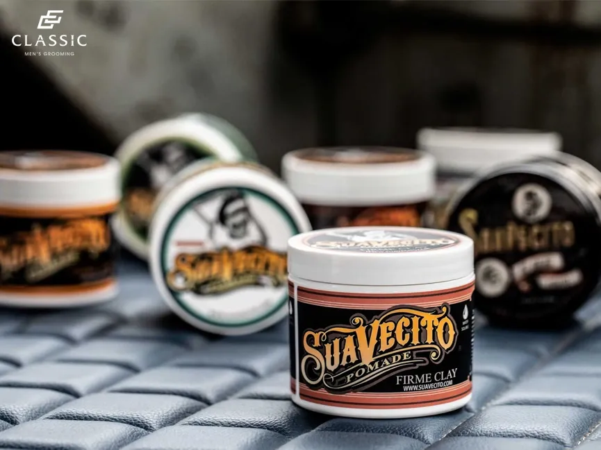 Bàn tay người đang thoa kem dưỡng ẩm sâu (Moroccanoil) lên mái tóc uốn cho nam giới