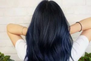 Nhuộm tóc màu đen ánh xanh tạo hiệu ứng bí ẩn, chỉ lộ màu dưới ánh sáng mạnh