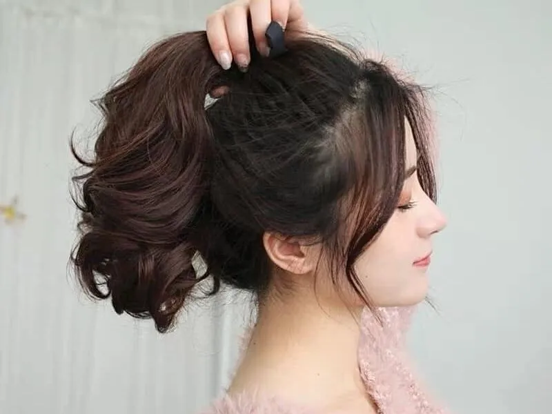 Cột tóc cao búi nửa đầu cho tóc uốn ngang vai
