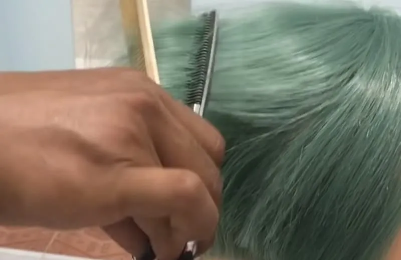 Hình ảnh minh họa kỹ thuật tách từng lớp tóc nhỏ bằng lược rồi dùng kéo tỉa để làm mỏng tóc