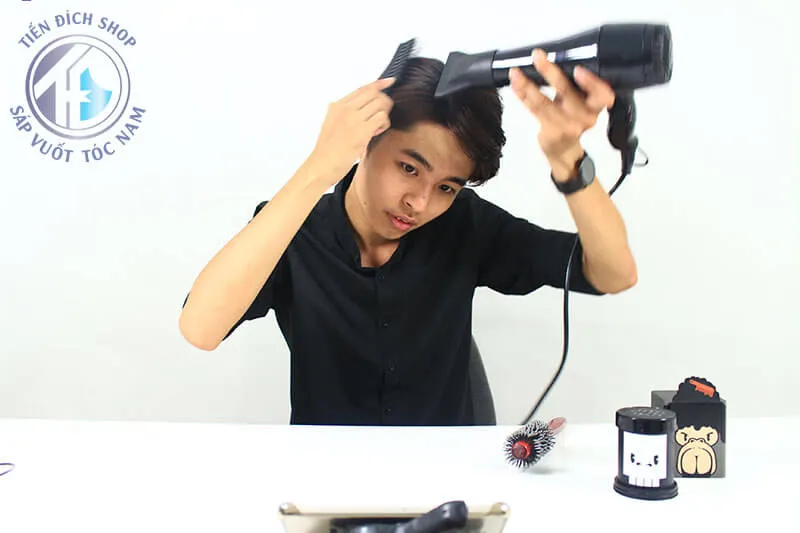 Người mẫu nam đã hoàn thành việc tạo kiểu tóc với độ phồng và nếp tóc rõ ràng, thể hiện kết quả sau khi sấy và vuốt wax