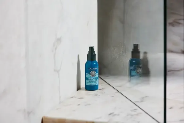 Người phụ nữ dùng dầu gội khô cho chân tóc để giảm bết dính