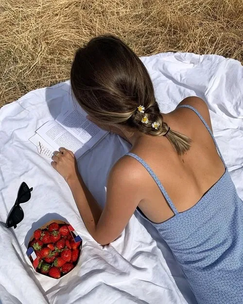 Người phụ nữ tóc bob ngắn đang tết một lọn tóc nhỏ sát da đầu ở phía thái dương