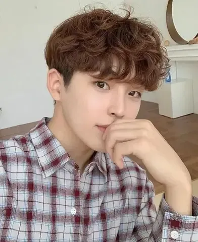 Phụ nữ đang giữ một lọn tóc gợn sóng nhẹ tự nhiên bằng tay