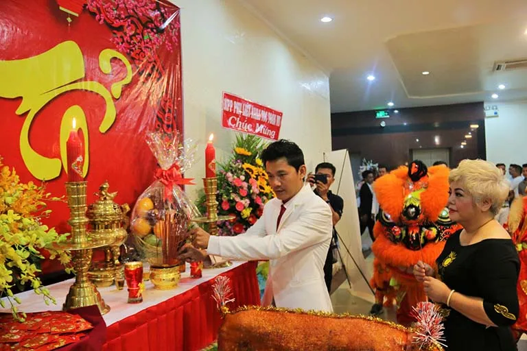 Một mâm cúng tổ nghề tóc với đầy đủ lễ vật như hoa quả, xôi gà, và đồ hàng mã được bày biện trang trọng