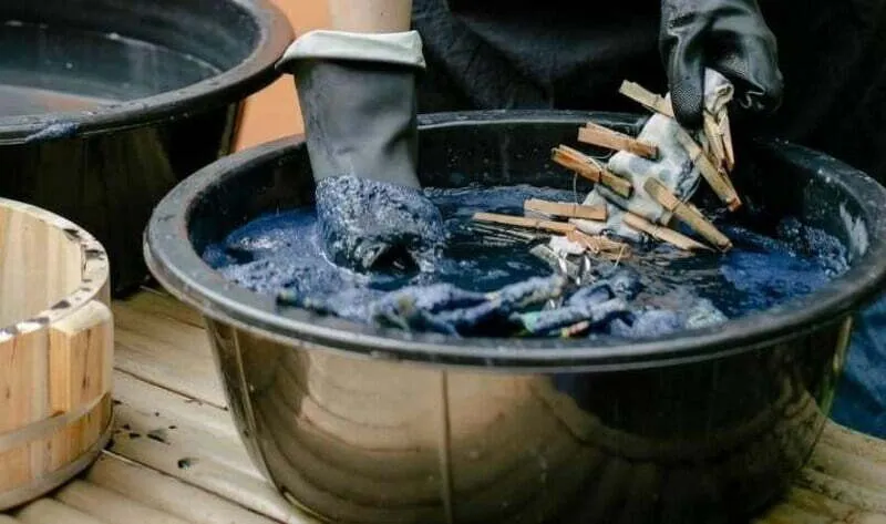 Tiến hành nhuộm bằng cách ngâm và khuấy đều quần áo