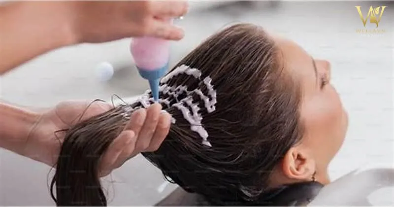 Một phụ nữ đang sử dụng mặt nạ dưỡng ẩm chuyên sâu cho mái tóc mới nhuộm màu xám khói