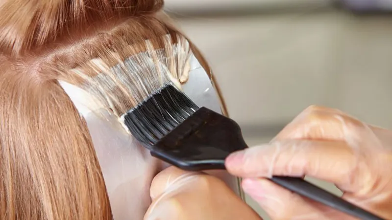 Dùng cọ quét đều thuốc nhuộm tóc màu hạt dẻ từ gốc đến ngọn